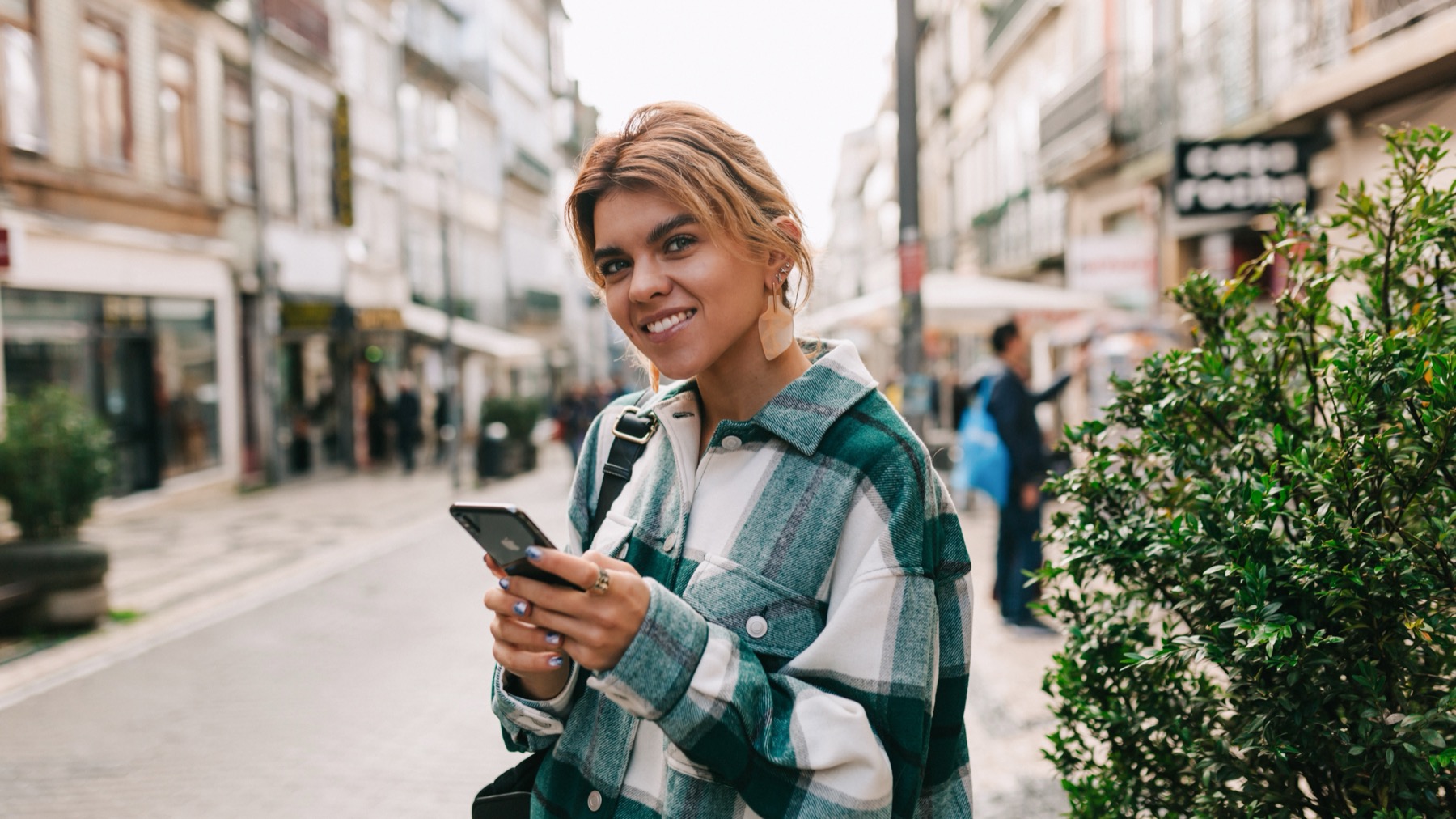 Traveler using a smartphone on a European street, illustrating Saily prices by country for travel eSIM plans
